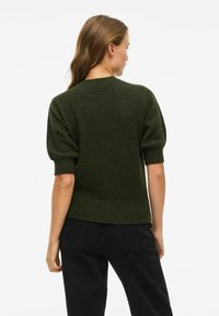 Pull en tricot vert foncé avec des manches courtes bouffantes, un col rond et un ourlet côtelé. Texture douce, design minimaliste, convenant pour un usage décontracté.