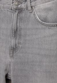 Jeans gri din denim cu un design clasic cu cinci buzunare, cusături vizibile, nasture metalic și o textură moale cu o ușoară finisare spălată.