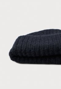 Cachecol de malha azul-marinho dobrado. Textura suave com padrão canelado. O material parece fofinho, exibindo variações subtis de cor e profundidade.