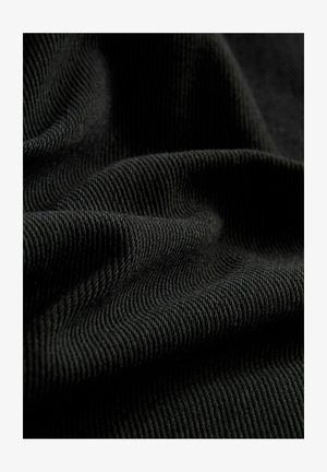 Black ribbed fabric with a textured surface, highlighting subtle folds and curves. The material appears lightweight and flexible.