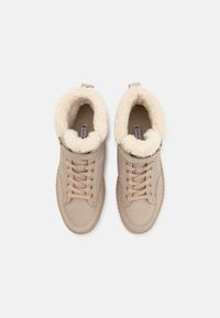 Zapatillas altas de ante en color beige con un suave forro de piel de color crema, suela de goma texturizada y sistema de cordones tradicional.
