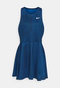 Robe bleue Nike sans manches avec motifs rayés géométriques et jupe évasée. Logo blanc Nike sur la poitrine haute.