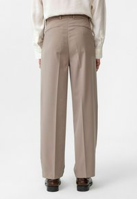 Beige wijde pantalons met een gladde textuur, hoge taille en achterzakken. Afgewerkt met een slim fit en minimale naden.