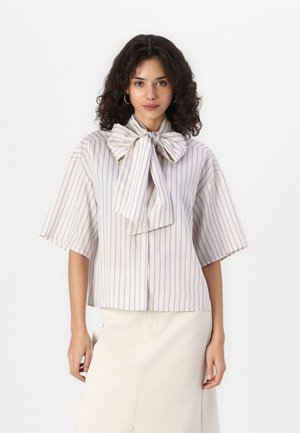 Kurzärmlige, hellfarbige Bluse mit vertikalen lila Streifen, featuring einer großen Schleife am Ausschnitt und einer kastigen Silhouette.