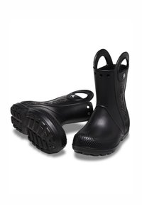 Bottes en caoutchouc noires jusqu'à la cheville avec une finition texturée, bout rond et poignées arrière pour un enfilage facile. Présente une semelle adhérente à motif.