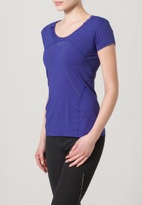 Maglietta atletica aderente a maniche corte di colore viola con scollatura a girocollo, caratterizzata da cuciture a contrasto e un design senza cuciture per comfort e flessibilità.