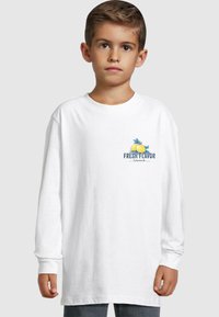 T-shirt alb cu mânecă lungă, având un grafic colorat "Fresh Flavor" cu lămâi pe piept. Material din bumbac moale, croială lejeră.