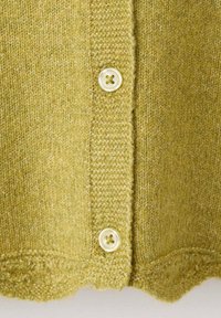 Grüne gestrickte Strickjacke mit strukturiertem Stoff, rundem Ausschnitt und drei Knöpfen mit gewelltem Saum. Die Knöpfe sind cremefarben.