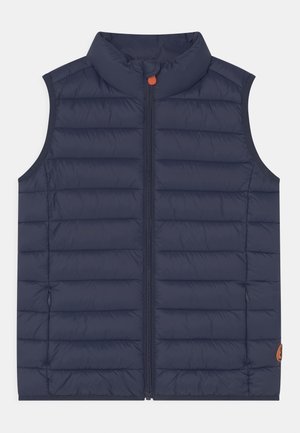 Navyblau gesteppte ärmellose Weste mit hohem Kragen, Frontreißverschluss und kleinem orangenem Reißverschlussanhänger, entworfen für kaltes Wetter.