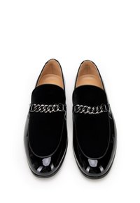 Zwarte patenten leren loafers met een zacht zwart suède paneel en een decoratieve zilveren kettingaccent. Gladde textuur met een rond neustype.