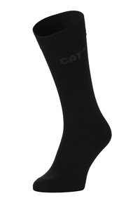 Chaussette en coton noir avec une bande supérieure côtelée et un orteil renforcé, présentant un logo CAT discret sur le côté. Texture lisse, design jusqu'au genou.