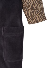 Black corduroy fabric with vertical ridges features a brown animal print long sleeve. Includes a patch pocket on the front.