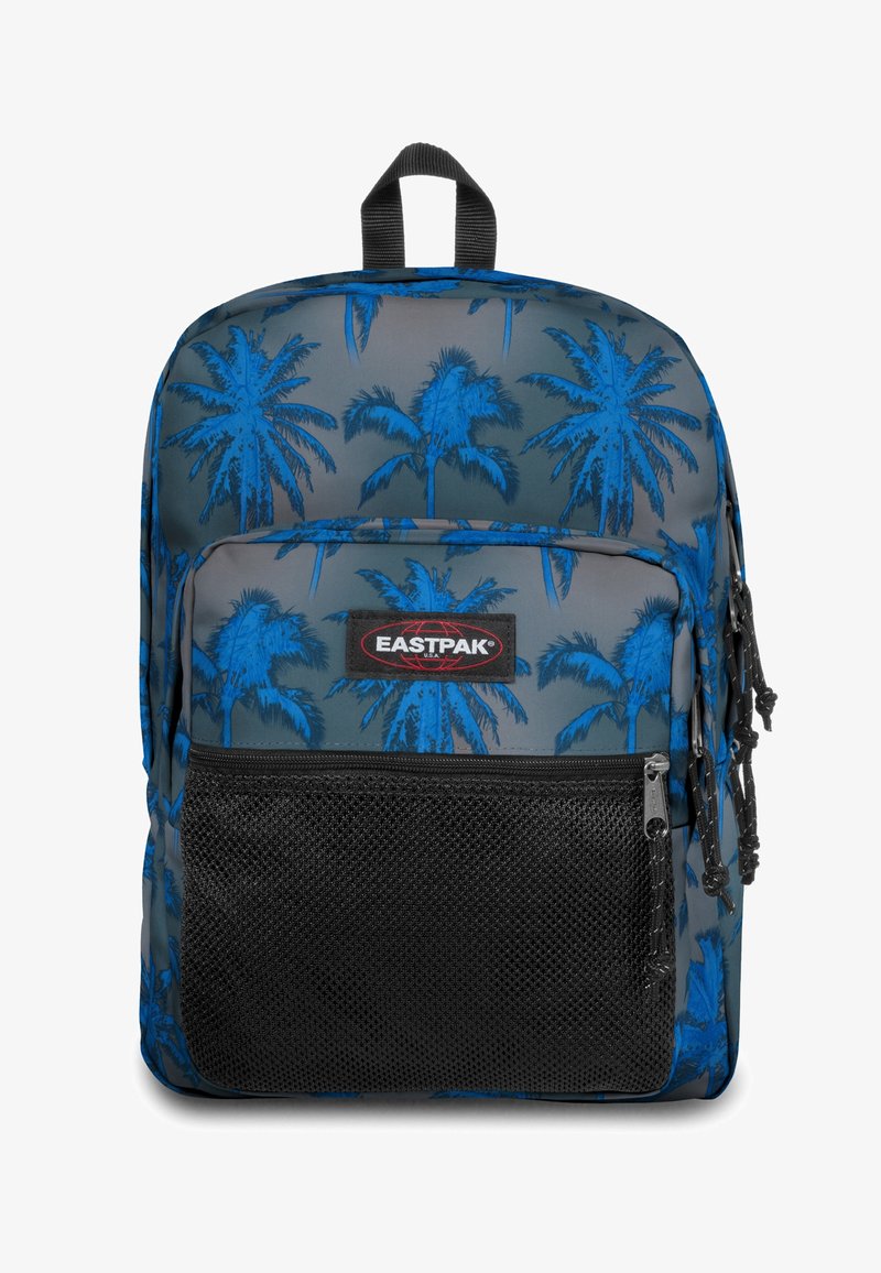 Plecak Eastpak na szarym tle z niebieskim wzorem palm, z czarną siateczkową przednią kieszenią i podwójnymi suwakami.