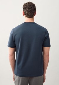 Navy blue cotton t-shirt with short sleeves, crew neckline, and a slightly fitted shape. Smooth texture, no visible patterns or logos.