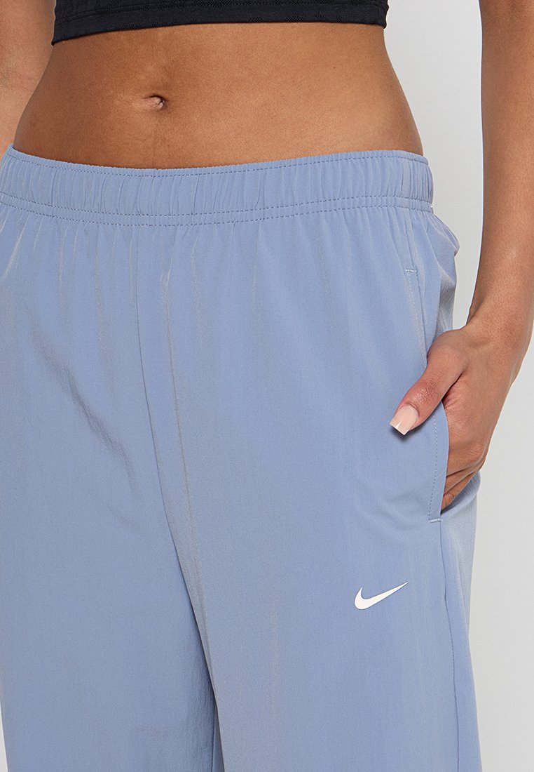 Pantalones deportivos de color azul claro con cintura elástica, bolsillos laterales y logo de Nike en blanco. Fabricados con un tejido suave y ligero.