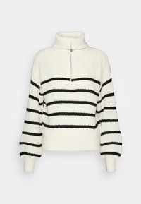 Pull crème à rayures horizontales noires, texture en maille épaisse, col montant et détail zippé au niveau du cou. Coupe ample avec manches bord-côtes.