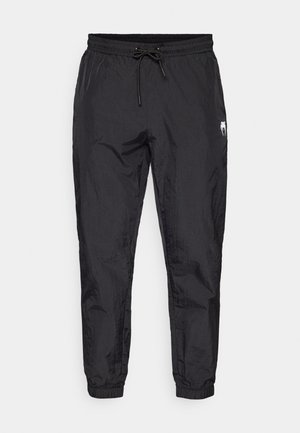 Schwarze, leichte Jogginghosen mit einem elastischen Bund und Kordelzug, schmal zulaufenden Beinen und subtiler texturierter Oberfläche.