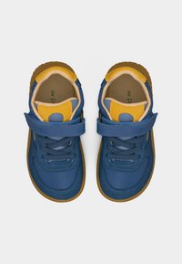 Μπλε και κίτρινα παπούτσια για νήπια με λουράκια βέλκρο και κορδόνια, από πάνω, σε λευκό απλό φόντο.