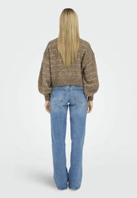 Pull en tricot texturé marron avec un design court. Assorti à un jean droit bleu clair avec des poches au dos.