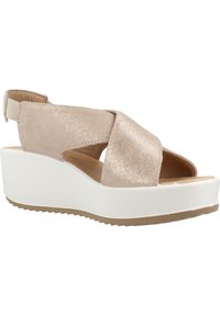 Beige metalické sandály na klínu s křížovými popruhy, otevřenou špičkou a elastickým zadním popruhem. Bílá platforma se strukturální béžovou gumovou podrážkou.