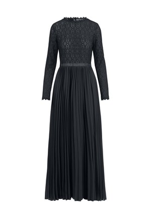 Robe en dentelle noire à manches longues, avec un motif de diamants texturé au niveau du corsage et une jupe plissée et fluide.