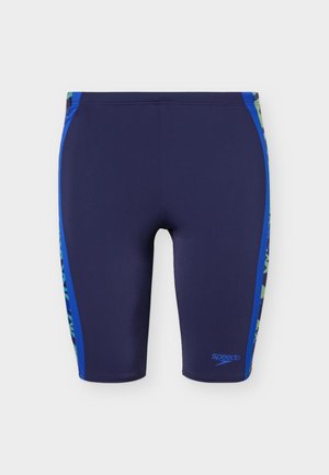 Tamsiai mėlynos vyriškos plaukimo glaudės su ryškiai mėlynomis šoninėmis juostelėmis ir žaliais raštuotais akcentais, ant kairės kojos mažas Speedo logotipas.