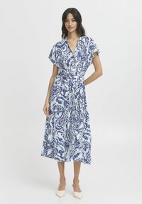 Rochie midi cu model paisley în nuanțe de albastru și alb, cu mâneci scurte, guler și talie legată. Material neted, siluetă fluidă.