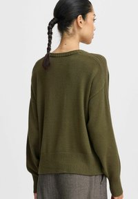 Olivgrüner Strickpullover mit geripptem Saum und Bündchen, verfügt über überschnittene Schultern und eine lässige Passform. Weiche Textur, schlichtes Design ohne Muster.