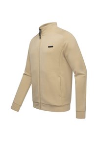 Béžová bundová mikina na zips s vysokým golierom, dlhými rukávmi, bočnými vreckami a hladkým povrchom. Obsahuje malé čierne logo na oblasti hrudi.