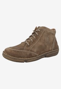 Botines de ante marrón con punta redondeada, detalles de costura y suela de goma texturizada. Presentan cierre con cordones y logotipo en relieve.
