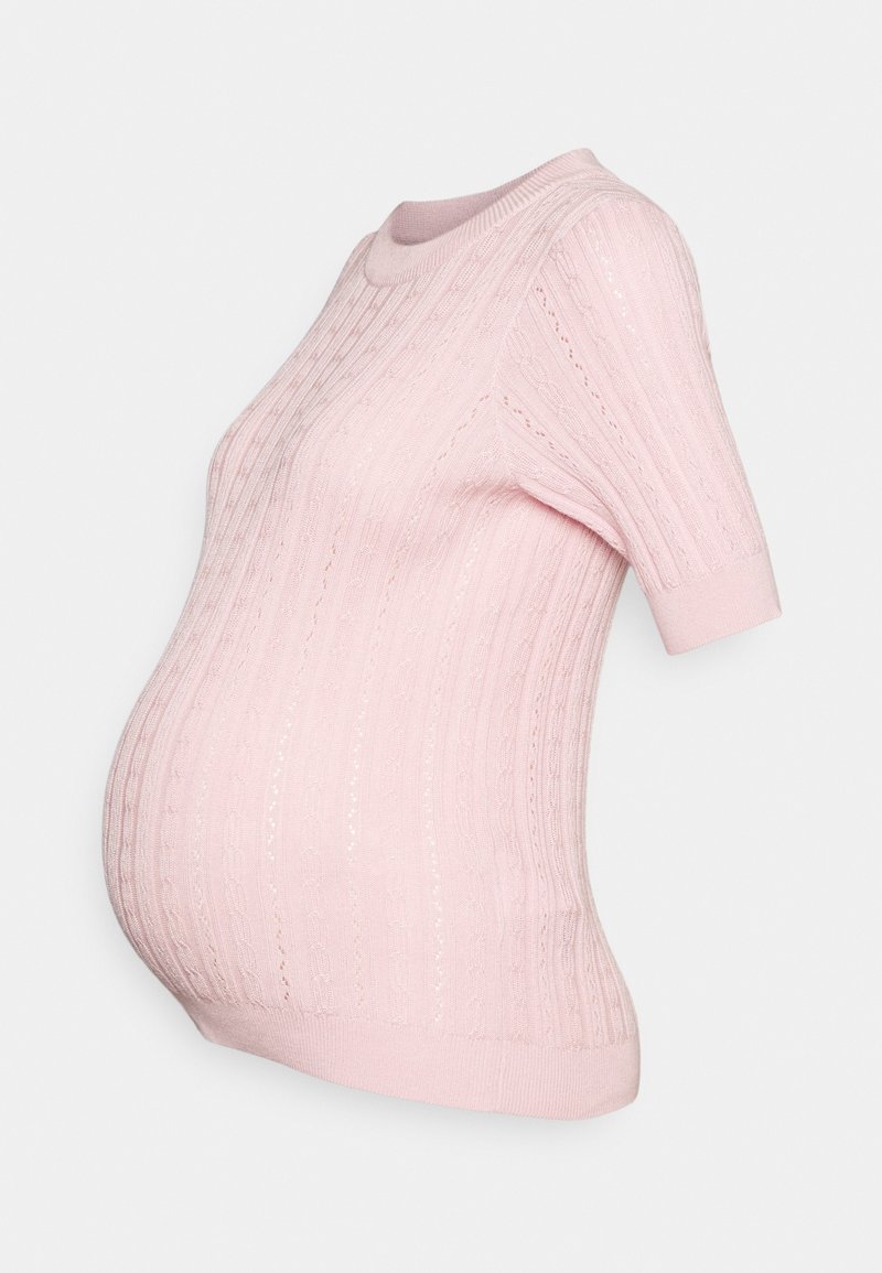 Pull de maternité en maille rose clair à manches courtes avec col rond et motif torsadé vertical.