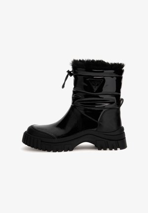Stivale alla caviglia lucido nero con collo di pelliccia, cordoncino regolabile, parte superiore testurizzata e suola in gomma resistente. Presenta un accento con logo sul lato.