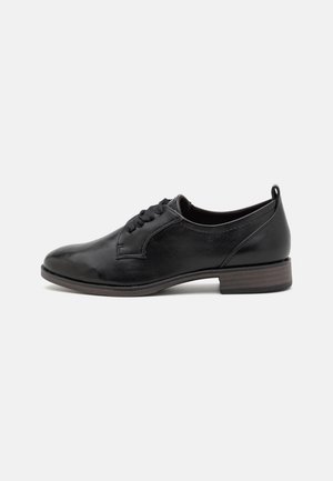 Chaussure de ville en cuir noir à lacets avec un petit talon en bois empilé et un bout rond, vue de profil sur fond blanc.
