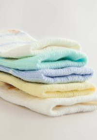 Stapel aus fünf gefalteten, weichen Baumwollsocken in Weiß, Gelb, Hellblau, Mintgrün und Weiß mit pastellfarbenen Streifen auf einer schlichten Oberfläche.