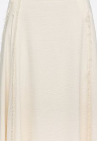 Tela blanca y texturizada con un borde ligeramente deshilachado, que cae con elegancia. El material parece ligero y transpirable, adecuado para climas cálidos.