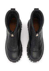 Botas negras hasta el tobillo con cierre de cremallera, parte superior de cuero liso, forro de tela texturizada y suela de goma resistente con tacos profundos.