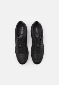 Black sneakers made of leather and synthetic materials with a smooth finish, featuring laces, breathable design, and Geox branding.