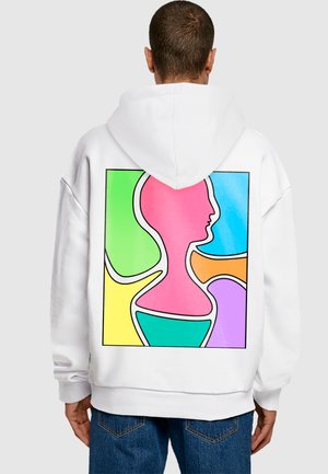 Hvid hættetrøje med et farverigt abstrakt design på ryggen, med pink, blå, grøn, orange og gule sektioner omrids i sort.