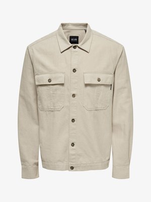 Beige Knopfleistenjacke aus Baumwollmischung, mit spitzem Kragen, zwei aufgesetzten Taschen mit Klappen und braunen Knopfverschlüssen.