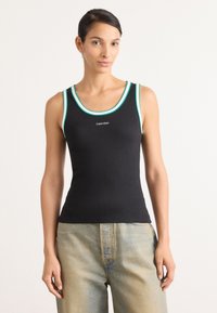 Crna majica bez rukava s tirkiznim detaljima i okruglim izrezom. Ima prilagođeni kroj i mali logotip "Calvin Klein" sprijeda.