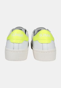 Sneakers bianchi con una finitura in pelle liscia, caratterizzate da un accento giallo neon sul tallone con "SUN68" impresso in bianco. Suola in gomma.