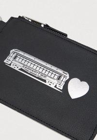 Pungă neagră cu fermoar, având o ilustrație argintie a unei armonici și un simbol al inimii pe față.