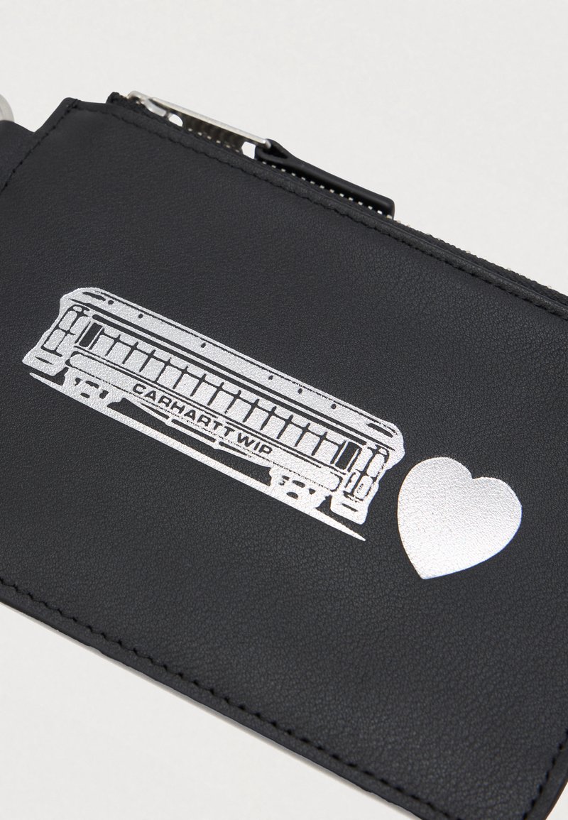 Sort lynlåspung med sølvillustration af en mundharmonika og et hjerte symbol på forsiden.