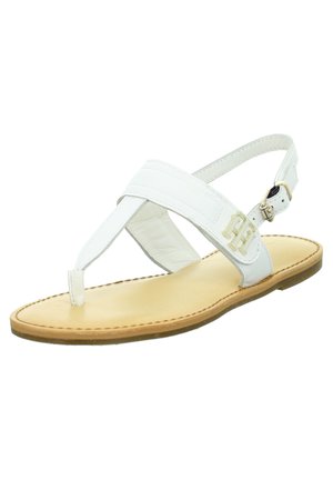 Sandale en cuir blanc à lanière avec semelle couleur tabac, bride de cheville réglable et détail du logo en métal doré sur le côté.
