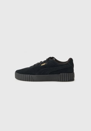 Black suede sneakers with a textured platform sole, featuring black laces and a small gold logo accent on the side.