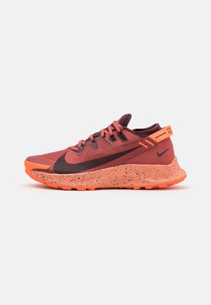 Roter und orangefarbener Nike-Laufschuh für Herren mit schwarzem Swoosh, Schnürdesign, gesprenkelter Sohle und Zuglasche an der Ferse auf einfarbigem Hintergrund.
