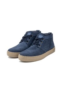 Botas de tobillo de ante azul marino con suelas de goma beige, puntera redonda y diseño con cordones. Presenta costuras mínimas y una textura suave.