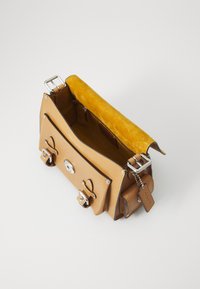 Tan leather handbag with silver hardware, featuring a flap closure, suede lining, and interior pockets for organization.