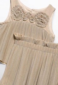 Abito beige a pieghe con tessuto texturizzato, fili metallici, dettagli a volant floreali sul colletto e cinturino arricciato.