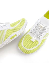 Limoengroene en witte sportschoenen met een ademend meshontwerp, elastische veters en een gestructureerde rubberen zool met een opvallend patroon.